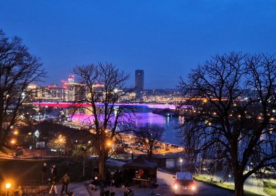 Nočni pogled na Savo v Beogradu in mostom, osvetljenim v barvah srbske zastave