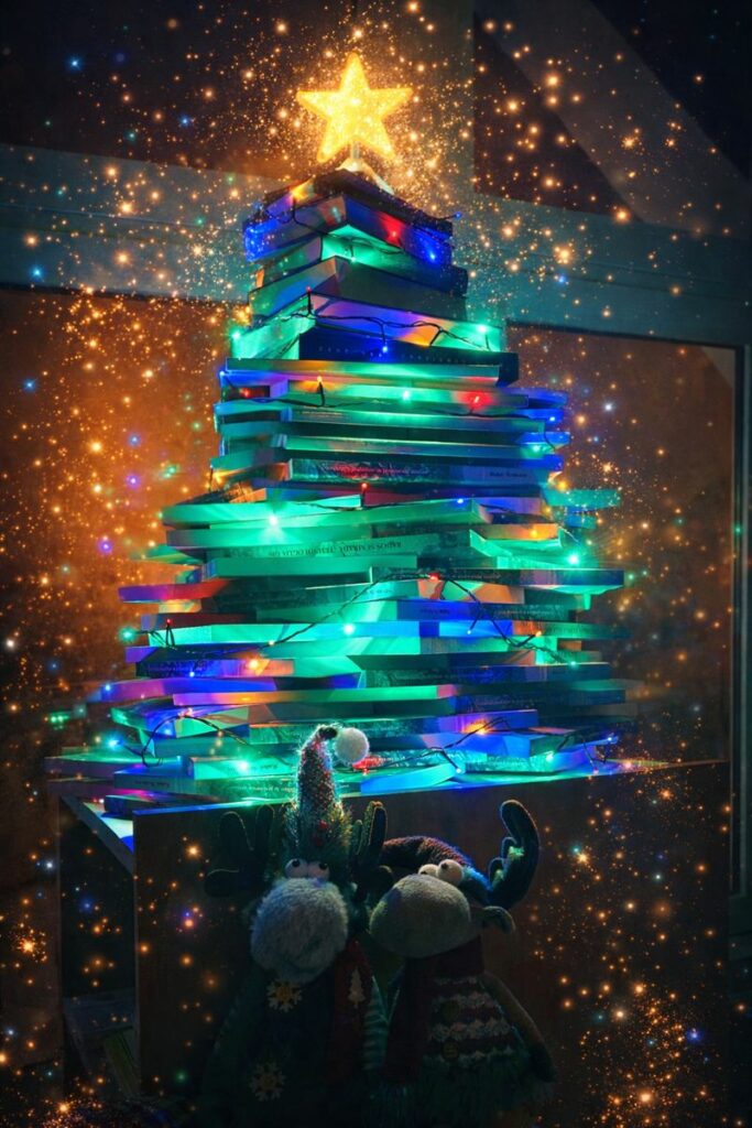 Okrašeno božično drevo, sestavljeno iz knjig.