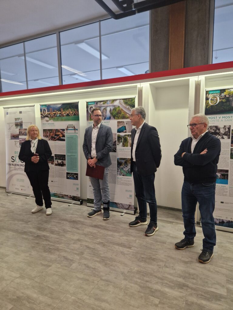 Štirje govorci na hodniku UL FGG, v ozadju razstava