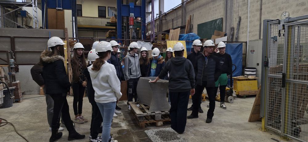 Otroci s čeladami na ogledu laboratorija.