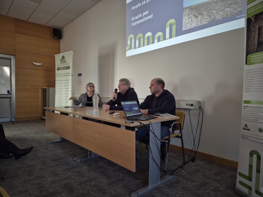 Na fotografiji slovenski člani čezmejne skupine strokovnjakov sedijo za mizo v učilnici. Na zaključni konferenci projekta predstavljajo svoje rezultate.